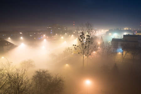 Aerial view on a city on a foggy nightの写真素材