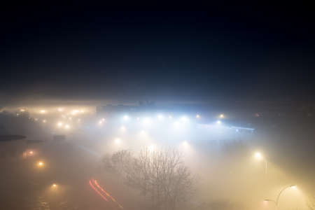Aerial view on a city on a foggy nightの写真素材