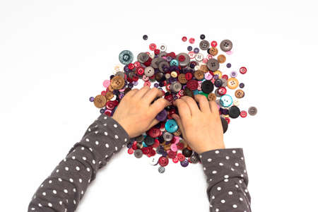 Little child hands playing with colorful buttonsの写真素材