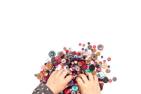 Little child hands playing with colorful buttonsの写真素材