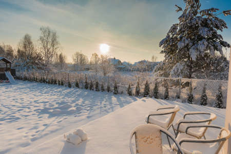 Backyard covered with snow on a sunny winter morningの写真素材