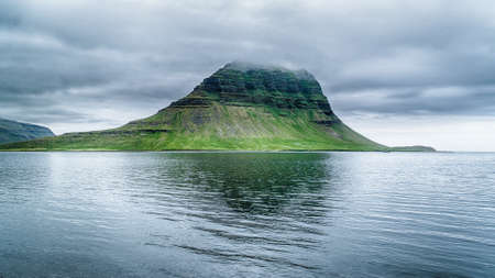Magnificent Kirkjufell Mountain with its tip covered with cloudsの写真素材