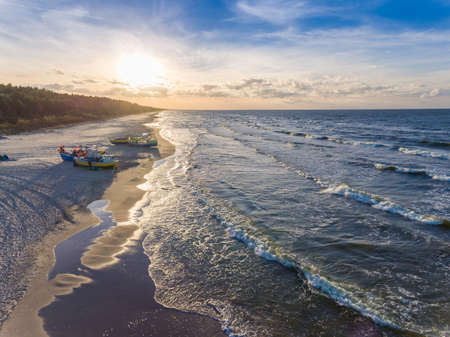 Setting sun over fishing boat moored at the beach in KÃ„ï¿½ty Rybackie, Poland