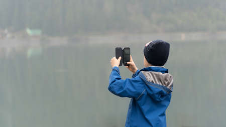 Boy taking photo with smartphoneの写真素材