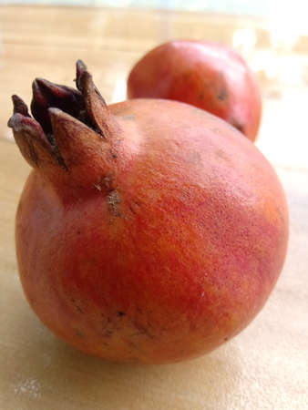 Two pomegranates placed facing opposite on floor.One behind the other.の写真素材
