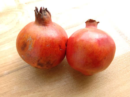 Two pomegranates placed on floor side by side to each other.の写真素材