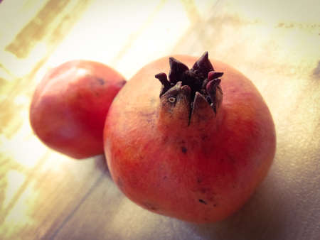 Two pomegranate placed on floor.Pomegranate have a pointed end towards the top.の写真素材