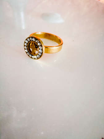 A good sharp picture of a golden ring with stones and cross in it and placed on a white background.