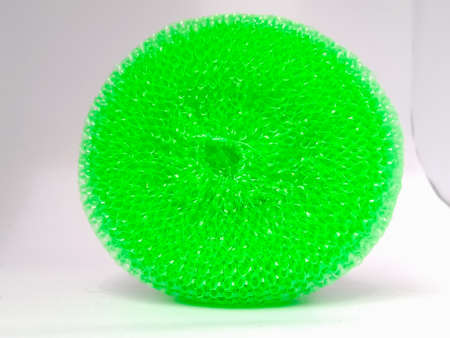 A front view of a plastic green scrubber placed vertically on the floor.The scrubber has pores in it.The ends are in focus and well exposed.の写真素材