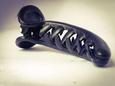 A long hair claw clip placed isolated in a white background.The black color of the clip have a shining under the light.The claws are visible in it.の写真素材
