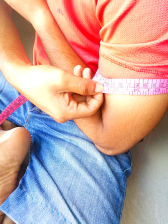 A Boy taking his own hand measurements for stiching purpose during covid conditions.The tape has...