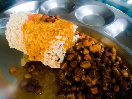 Kerala traditional food puttu and kadala in a steel plate.The bengal gram has black color and the puttu is made of wheat.We also see the coconut used in it.の写真素材