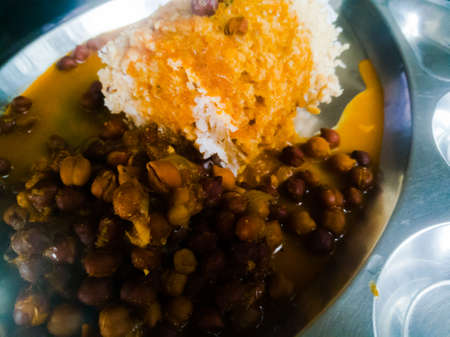 Kerala Traditional food puttu and Kadala curry in a steel plate.The bengal gram has black color and puttu is made of wheat.We also see the coconut used with it.の写真素材
