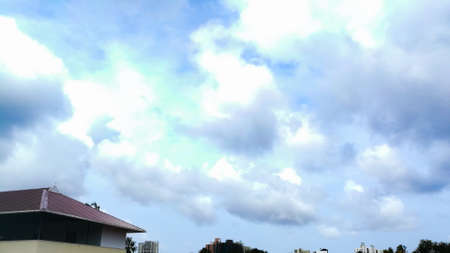 Rainy clouds from a far away distance on the top of trees.The clouds are dark and with dark blue color.The clouds are large enough and have different shapes.の写真素材