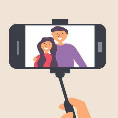 Young couple takes pictures on a selfie stick. Photographer