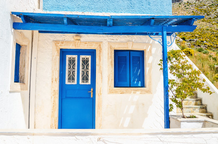 Wooden blue doors and windows with shade from roofing typical for Greek islands, Greeceの写真素材
