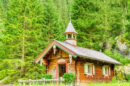 Mountain wooden chapel on a background of green pines, Zillertal, Austriaの写真素材