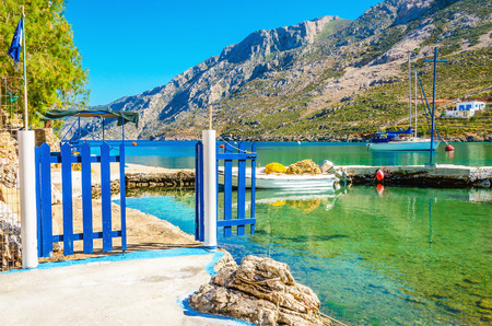 View of small port with boat and blue gate, Greeceの写真素材