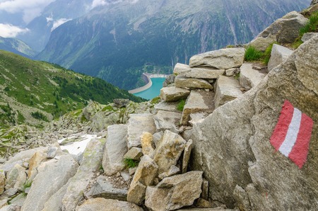 Beautiful alpine landscape with trail blazing and azure mountain lake in the background, Zillertal Alps, Austriaの写真素材