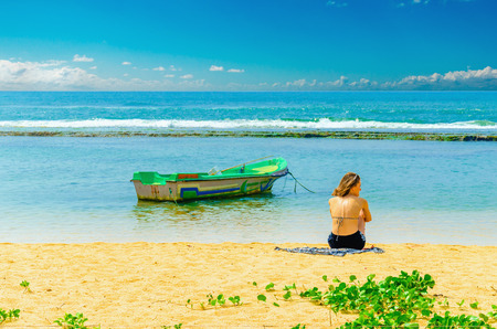 SRI LANKA, BERUWALA - JANUARY 9, 2015: Exotic beach with young girl, fishing boat and azure water, Sri Lanka, southern Asiaのeditorial素材