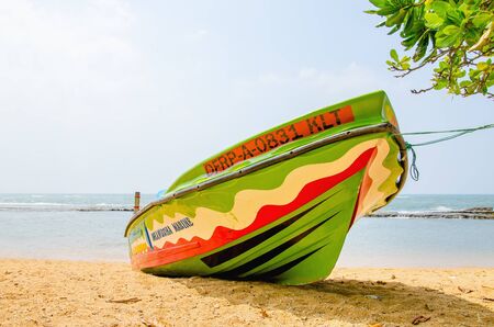 SRI LANKA, BERUWALA - JANUARY 9, 2015: Colourful boat on the background of the endless sea and a beautiful sandy beachのeditorial素材