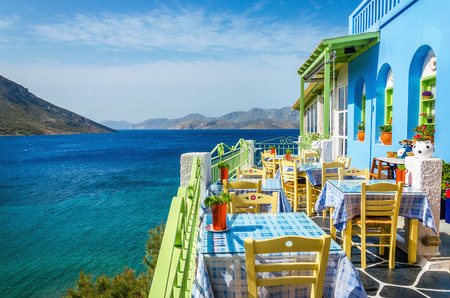 Typical Greek restaurant on the balcony blue building overlooking the sea, Greeceのeditorial素材