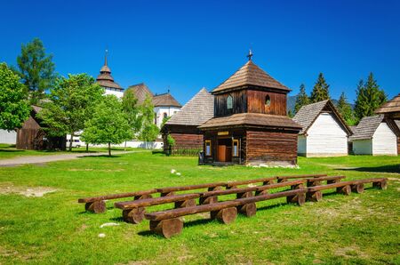Rare wooden bell tower with folk houses in open-air museum of Liptov, Pribylina, Slovakiaの写真素材
