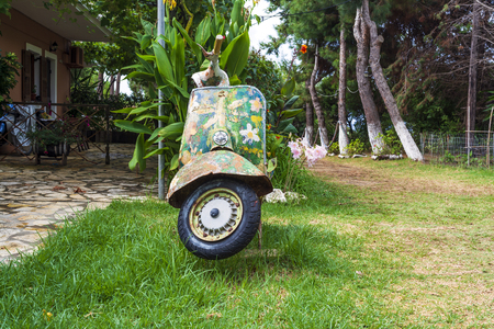 An old abandoned painted motorcycle in a garden at Corfu islandの写真素材