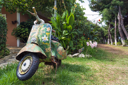 An old abandoned painted motorcycle in a garden at Corfu islandの写真素材