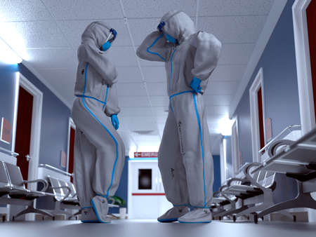 Doctor and nurse wearing Personal protective equipment and talking inside a hospitalの写真素材