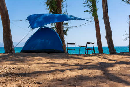 Tourist tent on sandy beach near the blue sea at Velika beach, Messinia. Greece. Camping on sandy beach.の写真素材