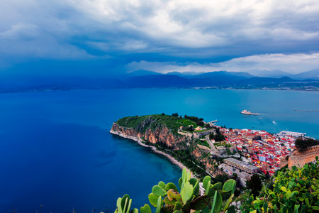 View from Palamidi on Nafplio city in Greece with port, Bourtzi fortress, and blue Mediterranean sea. Cloudy day.の写真素材