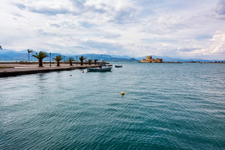 Traditional fishing boats and Bourtzi fortress in the picturesque city of Nafplio former capital of Greece, Argolida, Peloponnese.の写真素材