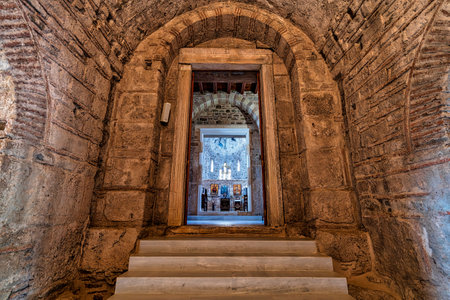 View through a stone archway into the interior of a Byzantine church in Christianoupolis, Greece, highlighting the altar and icons.の写真素材
