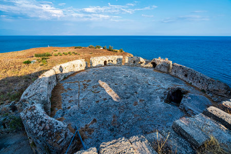 Circular stone ruins on the edge of Koroni's fortress offer sweeping views of the Mediterranean Sea,...