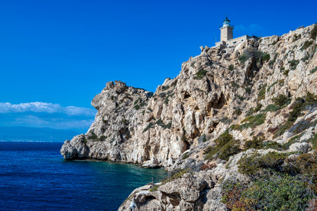 Lighthouse Melagavi, also known as Heraion Lighthouse, stands on a rugged cliff above the Corinthian Gulf in Loutraki, Greece, with breathtaking coastal views.の写真素材