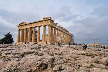 Athens, Greece - March 2, 2025: The Parthenon, Greece most iconic ancient temple, dominates the Acropolis landscape as visitors walk among its historic ruins.の写真素材