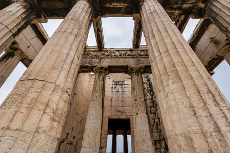 Looking up at the massive Doric columns and friezes of the Temple of Hephaestus in Athens' Ancient...