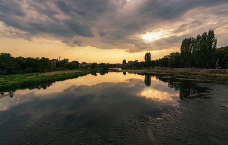 A breathtaking sunset over the Maritsa River in Plovdiv, Bulgaria. The golden hues of the setting...
