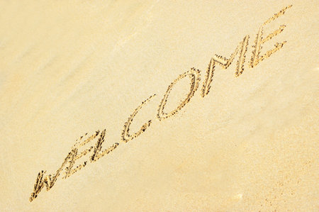 The word WELCOME written in the sand on a tropical and exotic beachの写真素材