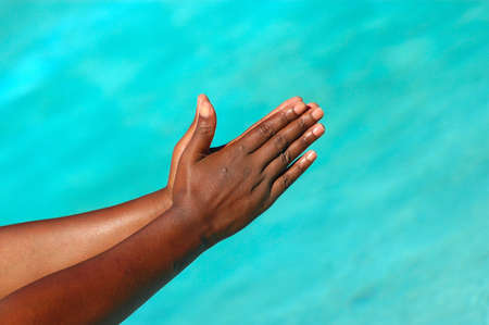 An African American woman holding her black hands together praying outdoors の写真素材