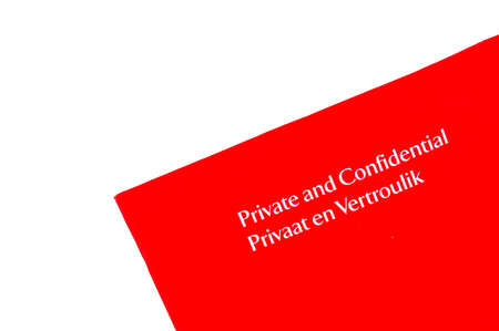 A letter in a red envelop from South Africa with the written words in white letters PRIVATE AND CONFIDENTIAL (English language) and also PRIVAAT EN VERTROULIK (Afrikaans language) isolated on white backgroundの写真素材