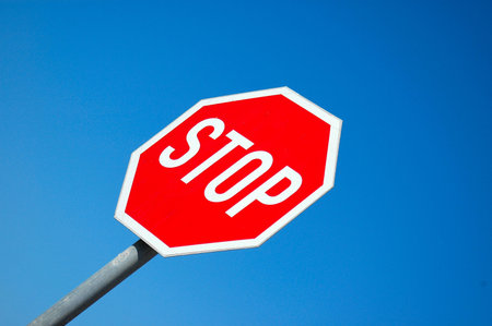 A traffic warning sign for STOP with blue sky backgroundの写真素材