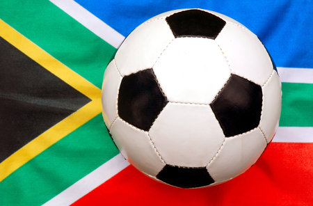 A traditional black and white soccer ball (focus on ball) on national flag background of the rainbow nation South Africa - the host country of the football world cup in 2010の写真素材
