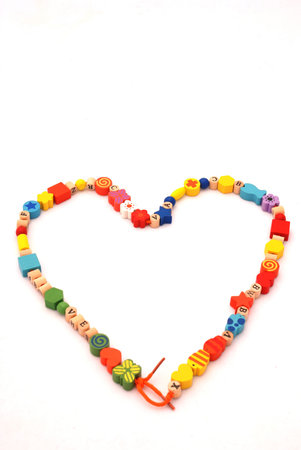A colorful necklace for kids in a heart shape isolated on white backgroundの写真素材