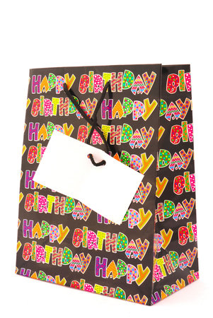 A colorful happy birthday gift bag with plain tag isolated on white backgroundの写真素材