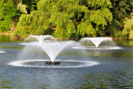 few fountains on the pond in the parkの写真素材