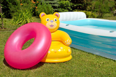 Inflatable armchair and tire near the poolの写真素材