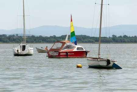 Two sailing boats and motorbike moored on the lakeの写真素材