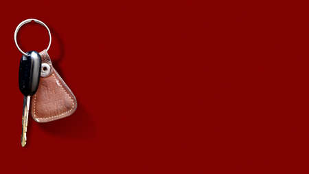 An isolated image of key of bike or motorcycle or scooter with ring in textured red background